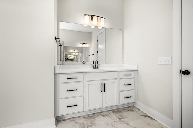 bathroom with baseboards, vanity, and marble finish floor
