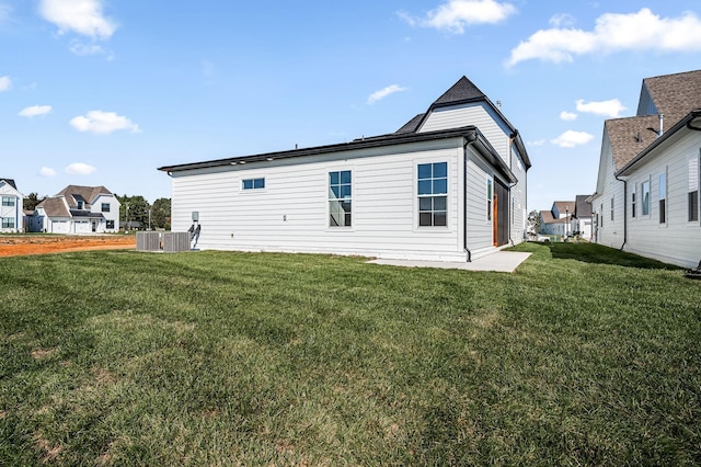 rear view of house with a lawn and central air condition unit