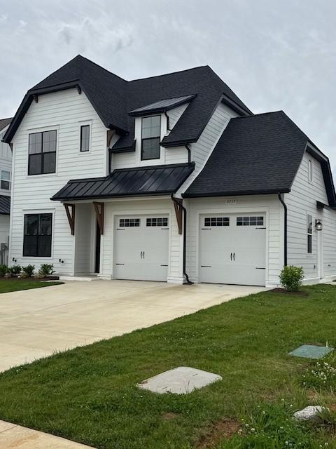 5739 Sagebrush Dr, Murfreesboro, TN 37129 - modern farmhouse with driveway, a standing seam roof, a front yard, a shingled roof, and a metal roof