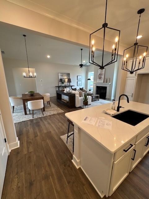 5739 Sagebrush Dr, Murfreesboro, TN 37129 - kitchen with a chandelier, dark wood-type flooring, white cabinetry, a fireplace, and recessed lighting
