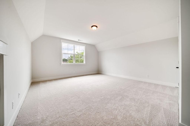 bonus room with carpet floors, baseboards, lofted ceiling, and visible vents