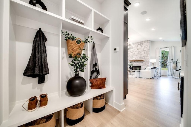 mudroom with recessed lighting, baseboards, a fireplace, and light wood finished floors