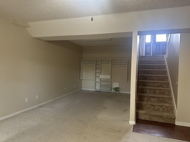 basement with carpet flooring, baseboards, and stairs