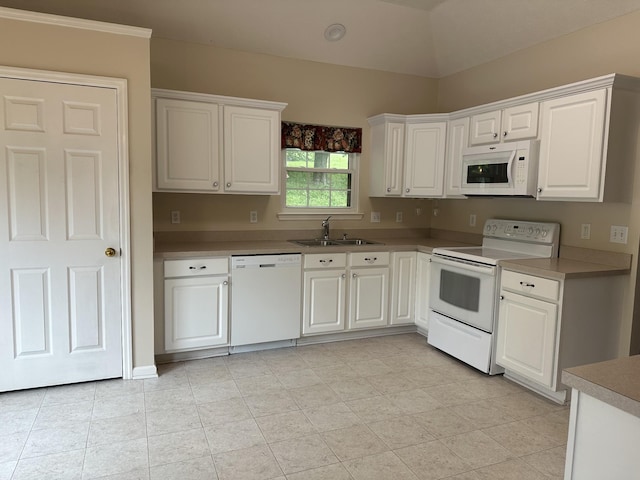 kitchen with white appliances, a sink, and white cabinetry