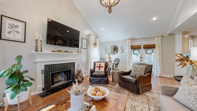 living area with recessed lighting, a fireplace with flush hearth, wood finished floors, and lofted ceiling