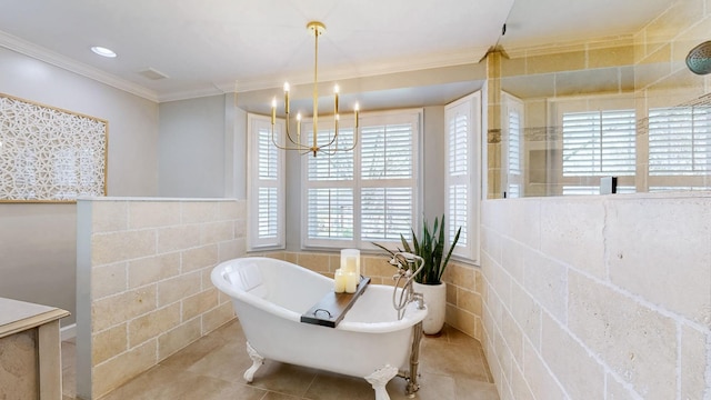 bathroom featuring a chandelier, tile patterned flooring, crown molding, and a freestanding tub