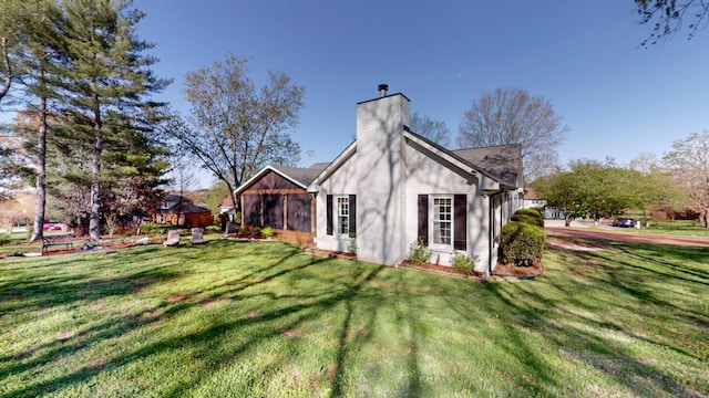 view of side of home featuring a yard and a chimney