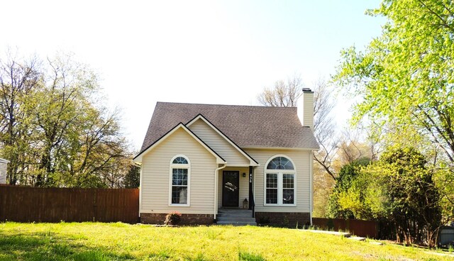 436 Bluff Dr, Clarksville, TN 37043 - view of front of house featuring a front yard, roof with shingles, fence, and a chimney