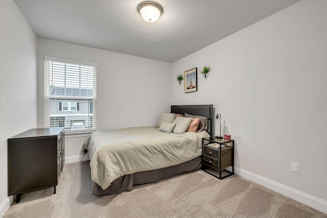 bedroom with light colored carpet and baseboards