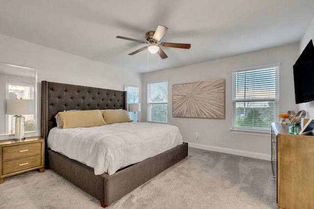 bedroom with light carpet, baseboards, and a ceiling fan