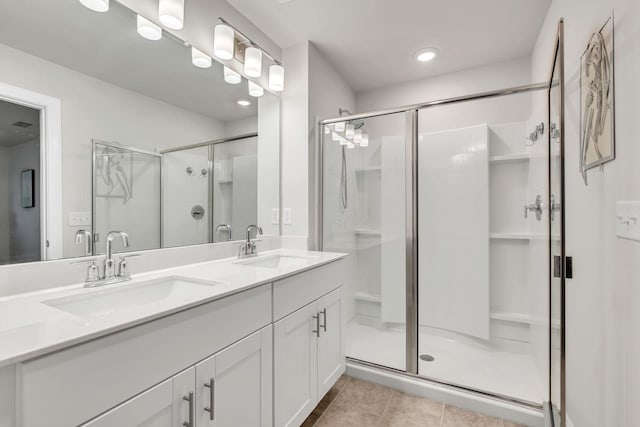 bathroom featuring a stall shower, a sink, and tile patterned flooring