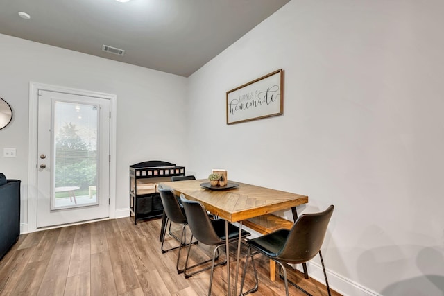 dining room featuring visible vents, baseboards, and light wood-style flooring