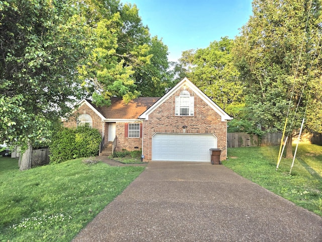 view of front of property featuring a front lawn, aphalt driveway, fence, brick siding, and an attached garage