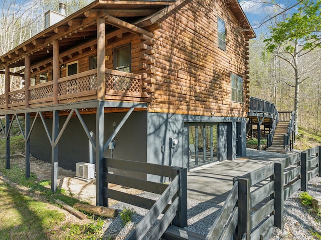 view of side of property featuring stairs, a deck, and log exterior