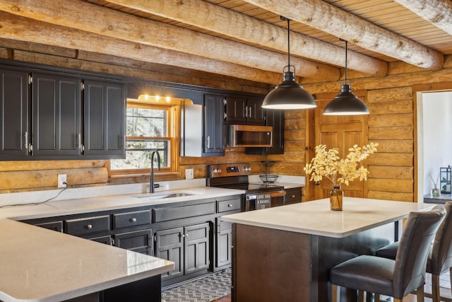 kitchen with a kitchen island, rustic walls, appliances with stainless steel finishes, a sink, and decorative light fixtures