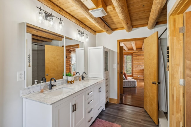 bathroom with a sink, beam ceiling, wood finished floors, and wood ceiling