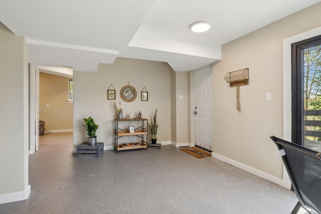 foyer with speckled floor and baseboards