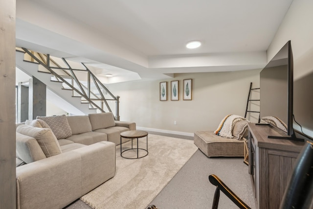 living area with baseboards and stairway