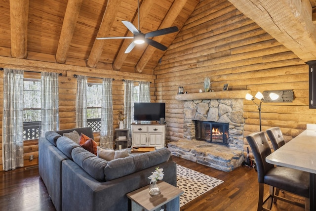 living room with rustic walls, wooden ceiling, a ceiling fan, and a healthy amount of sunlight