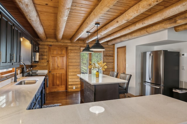 kitchen featuring log walls, a sink, dark wood-style flooring, freestanding refrigerator, and beamed ceiling