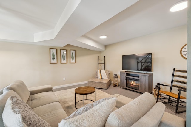 living area with carpet floors, baseboards, and a glass covered fireplace