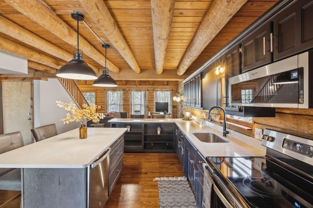 kitchen with a sink, a wealth of natural light, appliances with stainless steel finishes, and dark wood finished floors