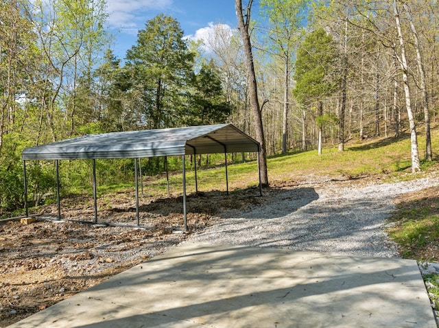 surrounding community featuring a view of trees and a detached carport