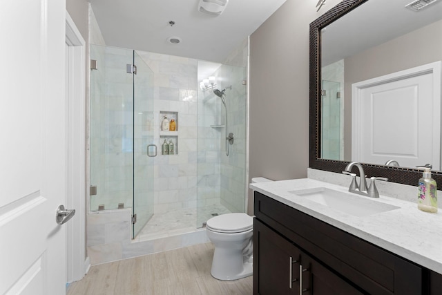 bathroom featuring a shower stall, vanity, visible vents, and toilet
