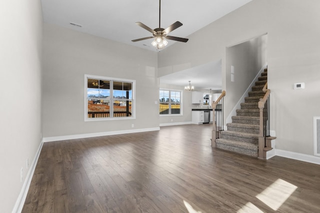 50 Gratton Ests, Clarksville, TN 37043 - unfurnished living room with dark wood-type flooring, stairs, a ceiling fan, a chandelier, and a towering ceiling
