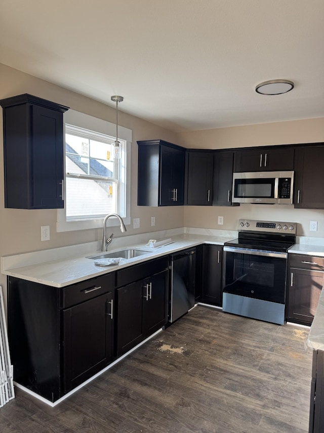 170 Cardinal Crk, Clarksville, TN 37040 - kitchen with appliances with stainless steel finishes, a sink, light countertops, dark cabinets, and dark wood-style floors