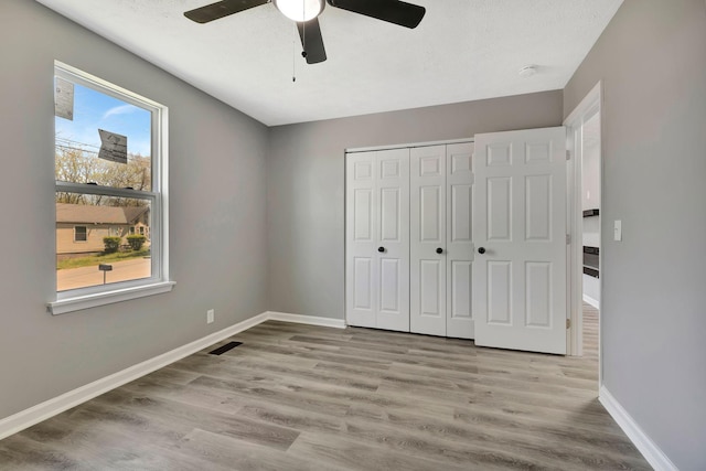 4817 Terragon Trl, Antioch, TN 37013 - unfurnished bedroom with baseboards, a ceiling fan, wood finished floors, and a closet