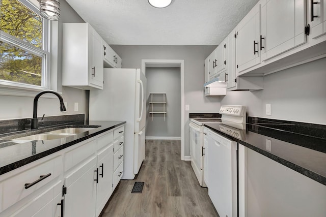 4817 Terragon Trl, Antioch, TN 37013 - kitchen with wood finished floors, a sink, a textured ceiling, white appliances, and white cabinetry