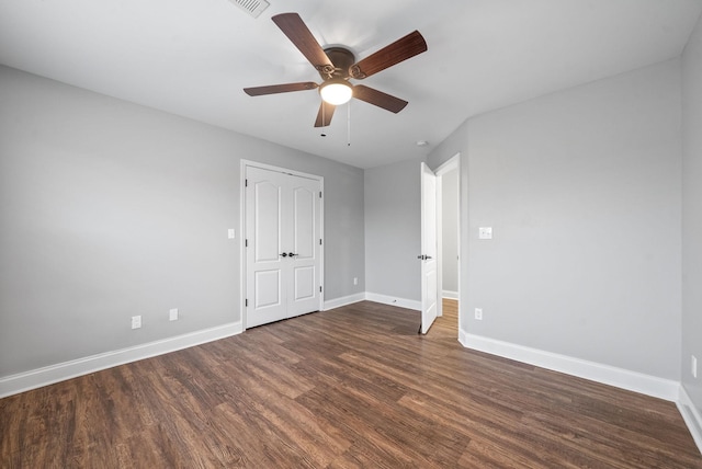 unfurnished room featuring baseboards, a ceiling fan, wood finished floors, and visible vents