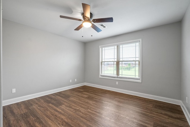 unfurnished room with visible vents, dark wood-style flooring, and baseboards