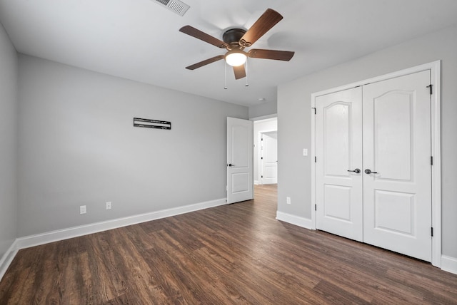 unfurnished bedroom with a ceiling fan, visible vents, dark wood finished floors, baseboards, and a closet