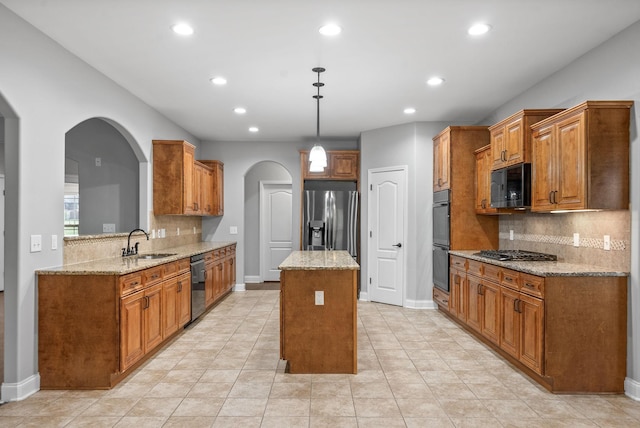 kitchen featuring decorative backsplash, a center island, brown cabinets, a sink, and black appliances