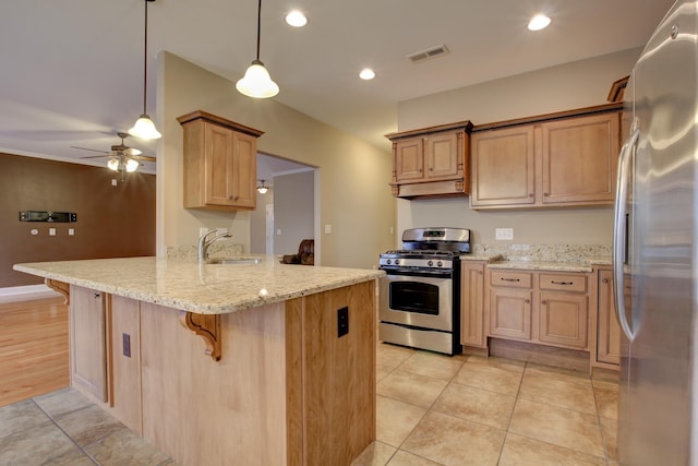 kitchen with visible vents, a sink, a peninsula, stainless steel appliances, and a breakfast bar area