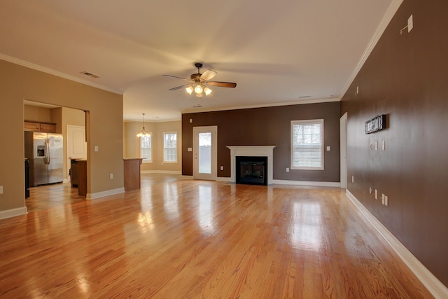 unfurnished living room featuring ornamental molding, visible vents, light wood-style floors, and ceiling fan with notable chandelier