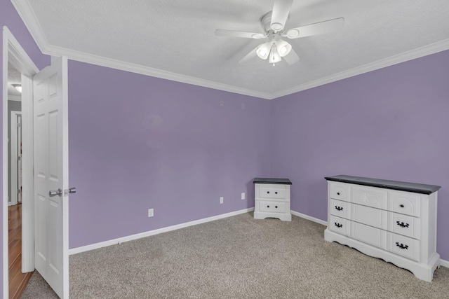 unfurnished bedroom featuring carpet flooring, baseboards, crown molding, and a ceiling fan