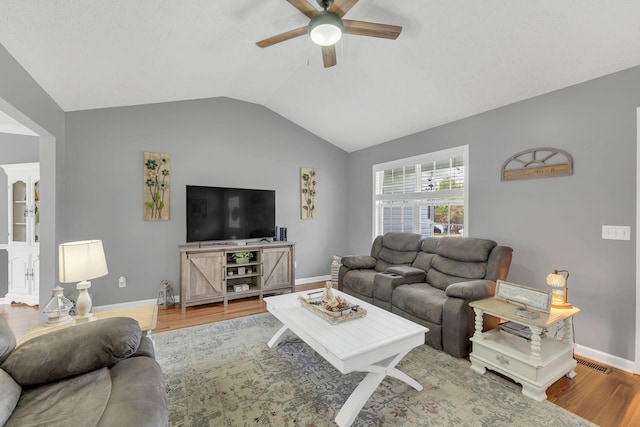 living area featuring ceiling fan, baseboards, wood finished floors, and lofted ceiling