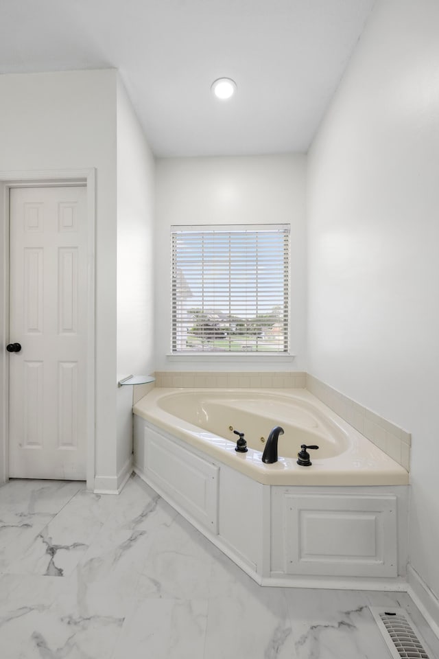 9401 Lazy Circles Dr, Ooltewah, TN 37363 - bathroom featuring marble look tile flooring, a garden tub, and baseboards