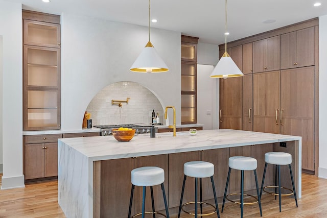 kitchen featuring backsplash, a kitchen bar, and light wood-style floors