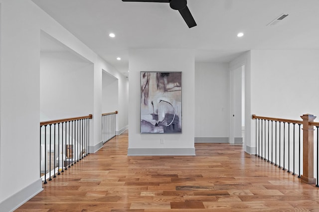 hall featuring recessed lighting, light wood-style floors, visible vents, and baseboards