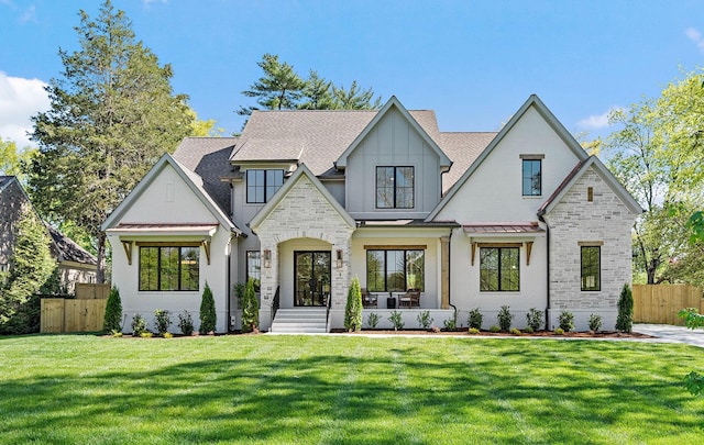 view of front of house featuring a front lawn, a shingled roof, fence, metal roof, and a standing seam roof