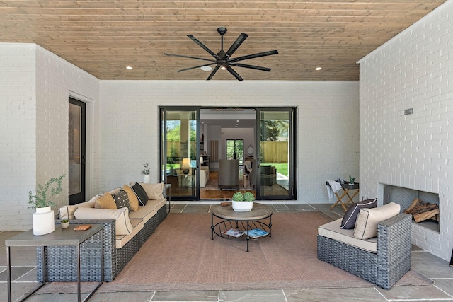view of patio with an outdoor living space with a fireplace and ceiling fan