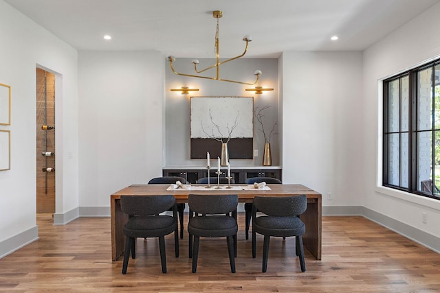 dining room featuring recessed lighting, light wood-type flooring, baseboards, and a notable chandelier