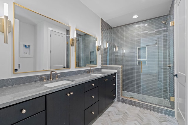 full bath with a sink, double vanity, and a stall shower