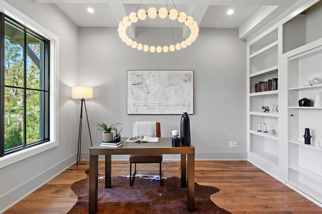 office space featuring baseboards, built in features, and wood finished floors