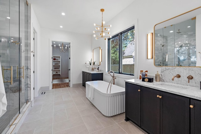 full bath with recessed lighting, an inviting chandelier, a sink, two vanities, and a stall shower