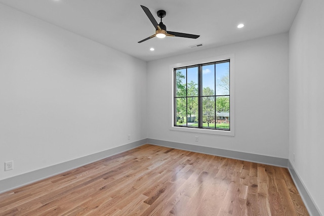 empty room featuring ceiling fan, baseboards, light wood finished floors, and recessed lighting